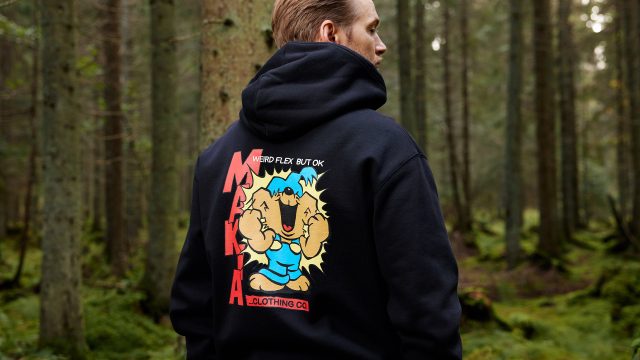 Man standing in forest wearing black Bamse Makia hoodie