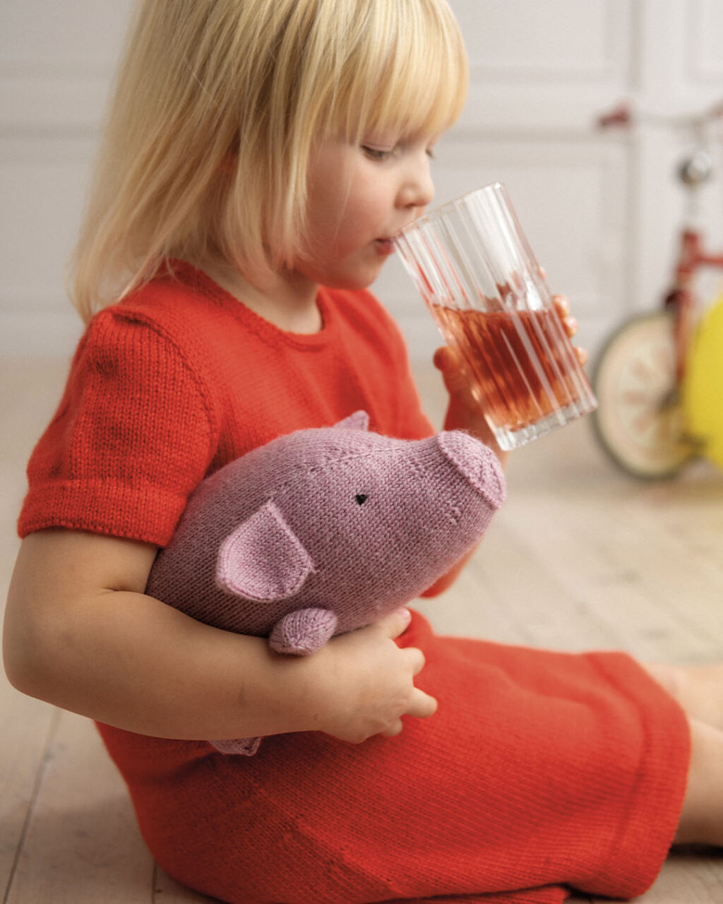 Girl holding knitted pig plush