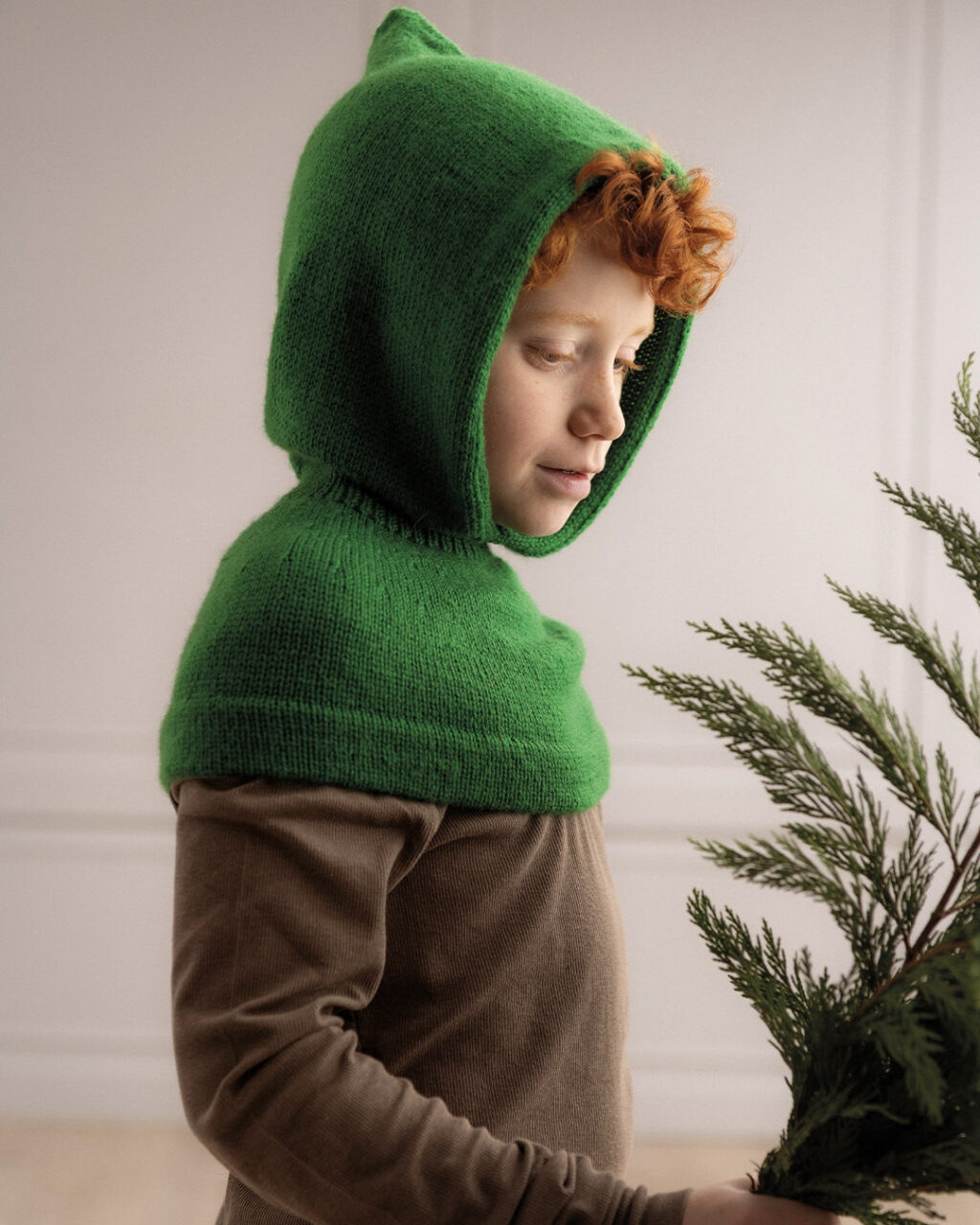 child wearing knitted green hood