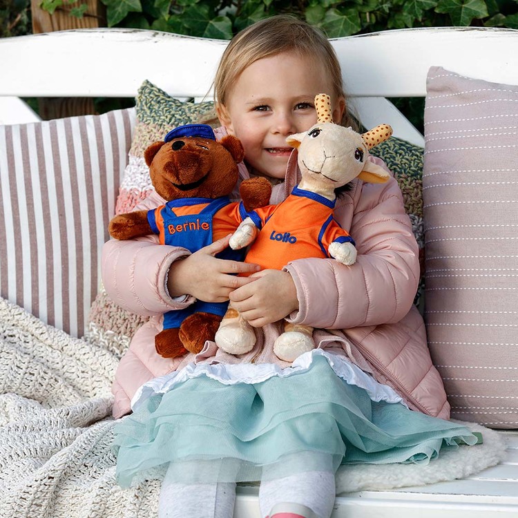 Girl holding lollo and bernie plush toys