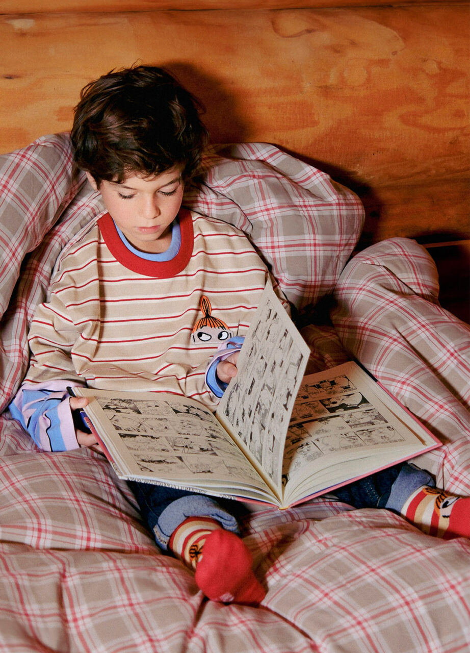 child wearing moomin shirt reading book