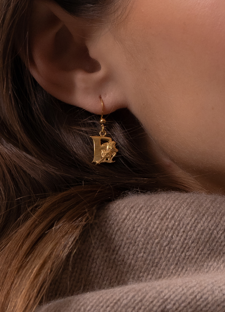Woman wearing a Skultuna Moomin earring with the letter E