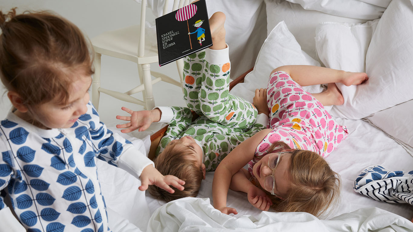 Three children wearing PO.P clothing with Stig Lindberg prints