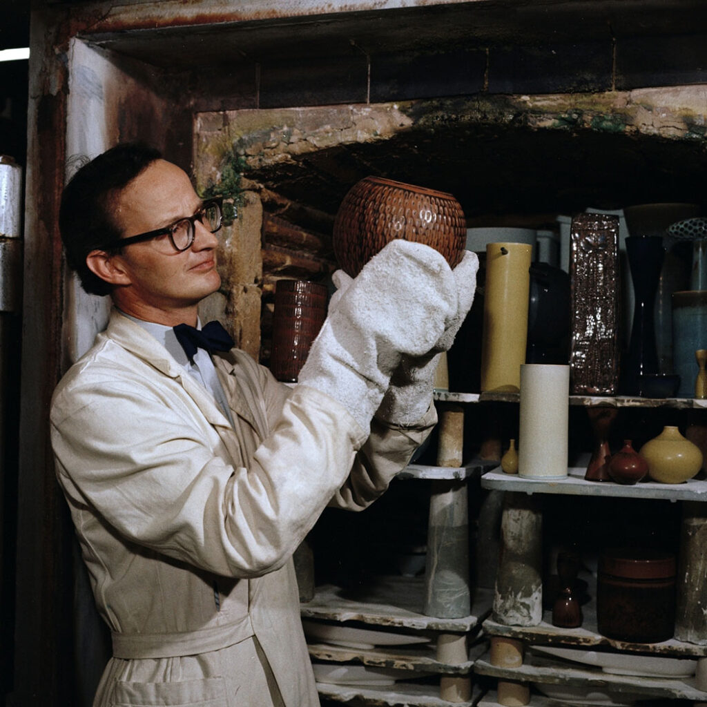 Photo of Stig Lindberg holding ceramic vase